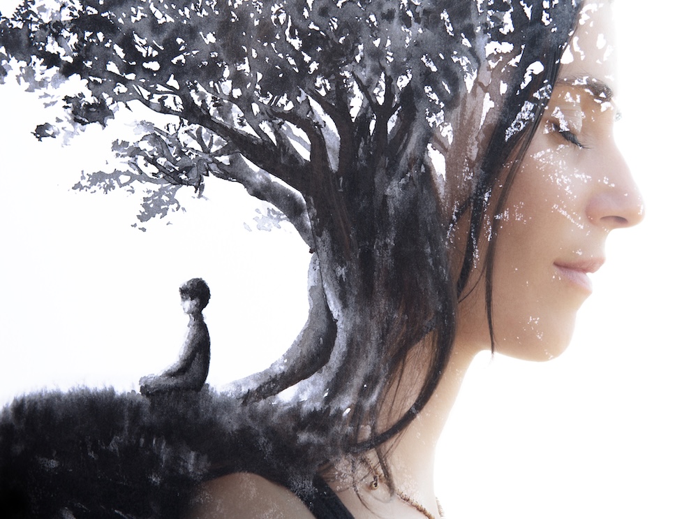 Paintography. Close up profile portrait combined with black ink painting of person meditating under a large tree